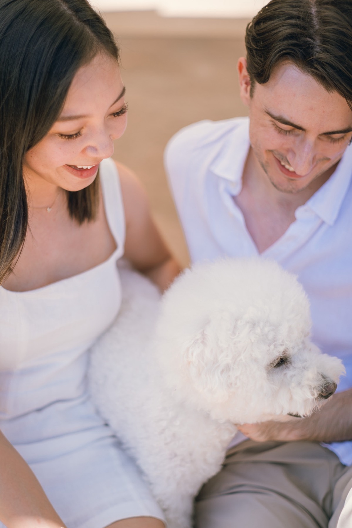 Close-up of Damon and Christina smiling down at Marlo in her lap