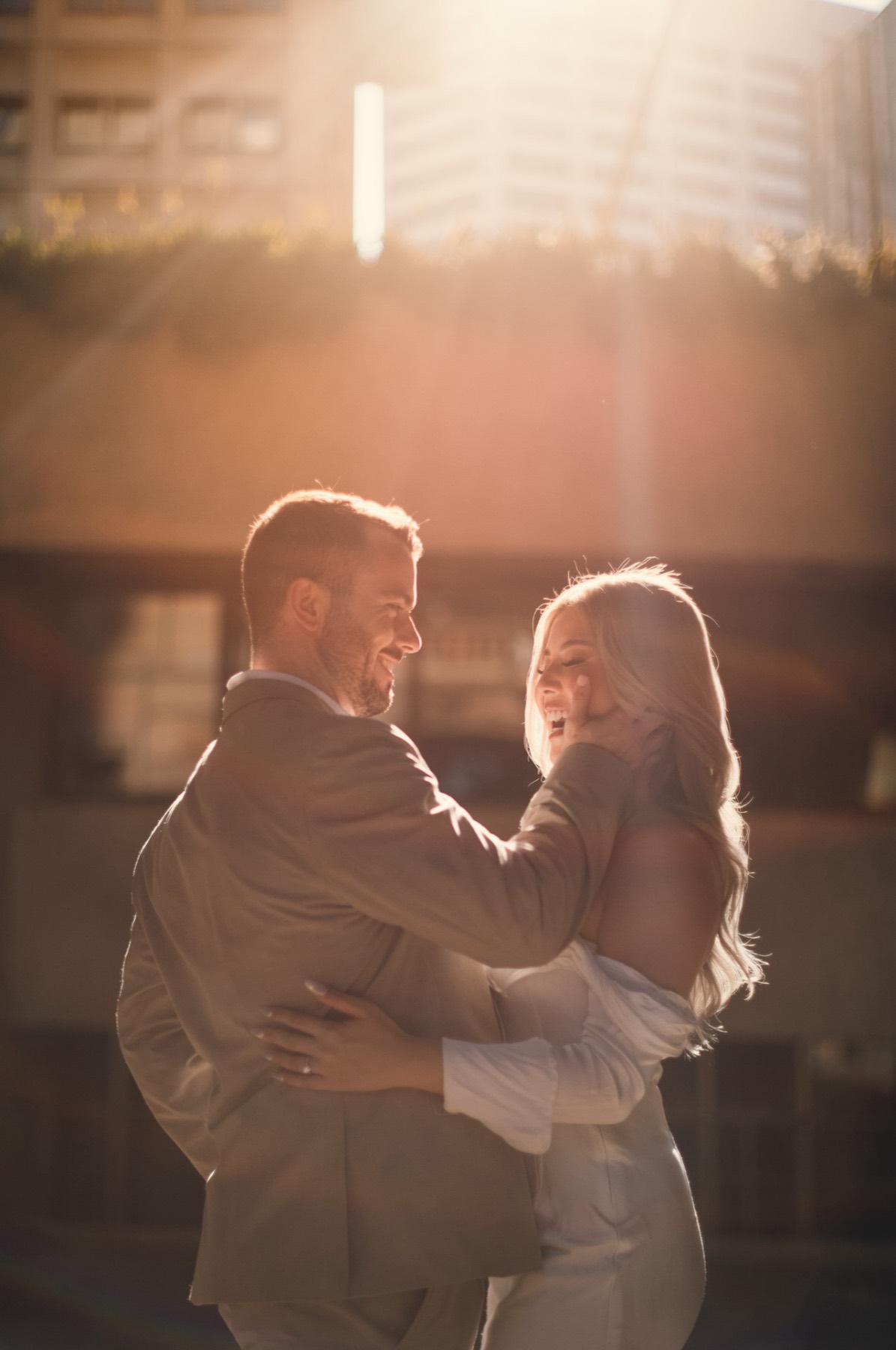 Kim laughing with her arms around Dave, both glowing in low golden backlight