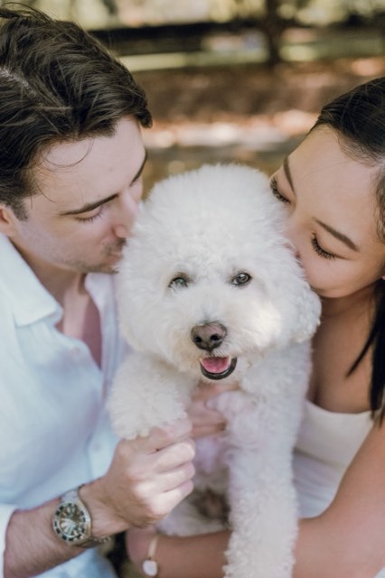 The couple both kissing Marlo's head, Marlo grinning at the camera