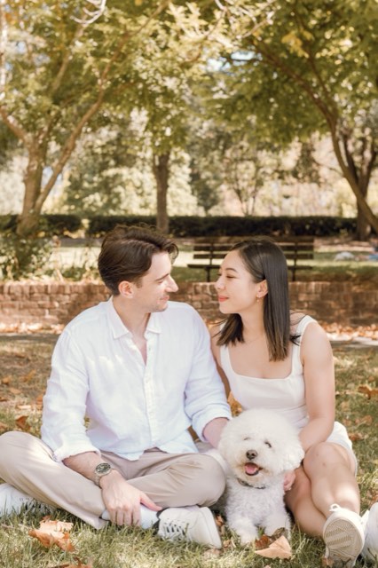 Damon and Christina smiling at each other on the grass, Marlo grinning in front