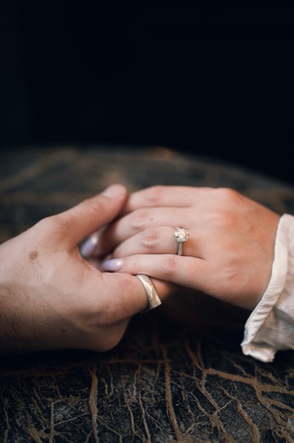Close-up of the couple's hands together, their rings catching the light